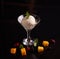 Ice cream with mascarpone cheese in a glass ice-cream bowl decorated with mint leaves on a dark background with slices of mango, b