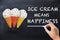 Ice cream means happiness text on chalkboard near three colourful and appetizing ice cream cones