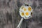 Ice cream metal scoop or spoon with edible chamomile flowers on a rustic wooden table