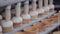 Ice-cream production line. Ice cream filling in cups, cones. Close up.