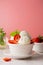 Ice cream scoop in bowl with fresh strawbery and mint. Delicious summer food treat, sweet dessert