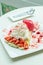 Ice cream strawberry crepe dessert on white dish wood table in c