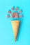 Ice cream waffle cone and marmalade candies on blue background, creative summer background.