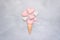 Ice cream waffle cone with pink and white thread heart on gray cement background. Valentines day greeting card with copy space.