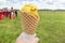 Ice cream in a waffle cone, in your hand. Holiday fair in the open air, people in the distance