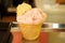 Ice cream in a waffle cup. Scoop of strawberry and lemon ice cream in a waffle cone isolated on pastry-shop background.