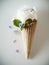 Ice creams immitation in waffle cone decorated mint leaves and flowers. Peonies flower in waffle cone with mint leaves.