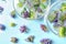 Ice cubes with flowers and glass bowls on background, flat lay