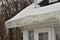 Ice dam and icicles in roof gutter of home.