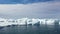 Ice desert shot from above. Polar iceland winter landscape aerial panorama. Frozen ocean, glaciers, icebergs, blue sky