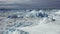 Ice desert shot from above. Polar iceland winter landscape aerial panorama. Frozen ocean, glaciers, icebergs, blue sky