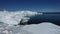 Ice desert shot from above. Polar iceland winter landscape aerial panorama. Frozen ocean, glaciers, icebergs, blue sky