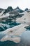 Ice floe Drifts at mountain cold lake. snowy peaks reflected in water