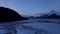 Ice flowing by mountains in Alaska