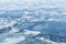 Ice fragments covered with show on frozen river water