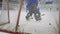 Ice hockey, goalie in uniform stands at gate and catches puck from rival at rink during championship, scoring close-up
