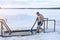 Ice hole on the lake. A man bathes in ice water