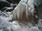 Ice icicles on the rocky mountain with a snow