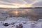 Ice melting on the St. Lawrence River during a hazy late winter sunrise