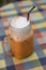 Ice milk tea with straw in cube glass with handle in selective focus