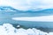 Ice on Okanagan Lake with snow covered rocky shoreline and mountains