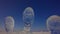 Ice sculptures. Abstract human heads. Glacial figures standing over blue sky.