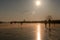 Ice skater silhouette on a frozen windmill canal at sunrise moment