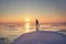 Ice skating on frozen lake at orange sunrise