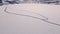 Ice skating road on a large frozen lake with people skating along. Top down aerial video.