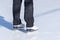 Ice skating, woman legs wearing white leather skates, training on a frosen snowy skating rink in winter close up