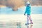 Ice skating. Young girl is skating on a natural frozen lake