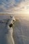 Ice and snow broken formation on frozen coast at sea in cold winter evening sunset sky clouds light