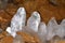 Ice stalagmites in a cave illuminated by candles.