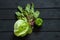 iceberg cabbage lettuce leaves Swiss chard and sweet green peppers on a wooden black table, vegetables for salad