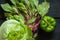 iceberg cabbage lettuce leaves Swiss chard and sweet green peppers on a wooden black table, vegetables for salad