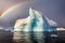 iceberg calving with a rainbow appearing in the spray
