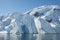 Iceberg with cave and mountain behind it