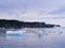 Iceberg filled scenery in Twillingate Harbour with steep rugged cliffs stretching across the horizon