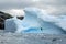 Iceberg floating near a rocky shore in Antarctica