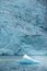 Iceberg floats in crystal clear water of Mosevatnet Lake with Folgefonna Glacier in the background