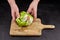 Iceberg lettuce crisphead lettuce in hands on wooden cutting board