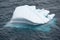 Iceberg shining in white, turquoise color in dark blue riffled Southern Antarctic Ocean, Antarctica