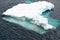 Iceberg shining in white, turquoise color in dark blue riffled Southern Antarctic Ocean, Antarctica