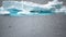 Iceberg shining in white, turquoise color in dark blue riffled Southern Antarctic Ocean, Antarctica. Penguin in foreground.
