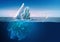 Iceberg under blue sky with underwater part and water line