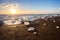 Icebergs on the cost of the black sand beach in the rays of the rising sun,  Jokulsarlon,  south Iceland