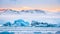 Icebergs float on Jokulsarlon glacier lagoon at sunrise