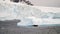 Icebergs floating in the ocean near the snowy peaks of Antarctica.