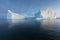 Icebergs in front of the fishing town Ilulissat in Greenland. Nature and landscapes of Greenland. Travel on the vessel among ices.