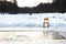 Icebound chair near opening water in frozen lake